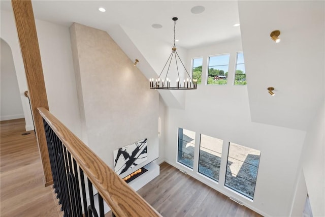 stairway featuring recessed lighting, wood finished floors, baseboards, and a chandelier