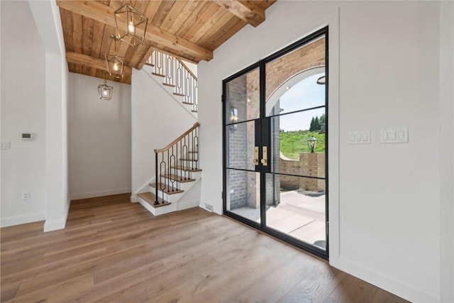 interior space with beam ceiling, wood finished floors, baseboards, wood ceiling, and stairs