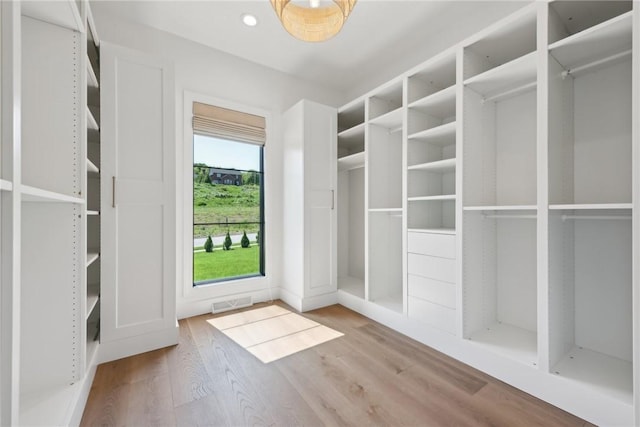 walk in closet featuring wood finished floors and visible vents