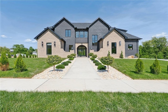 view of front of home with brick siding and a front lawn