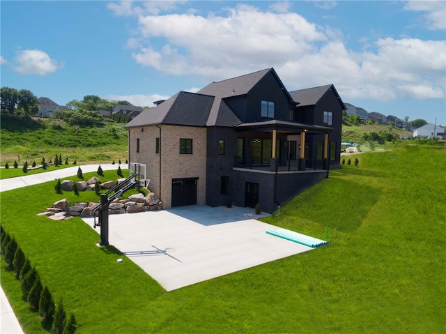 back of property with a yard, a patio area, and a garage