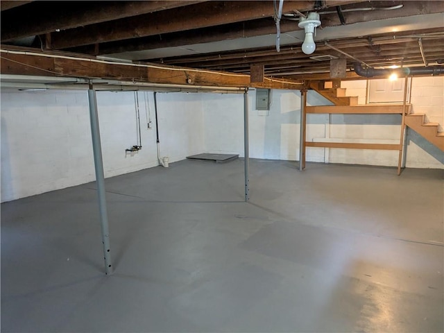 unfinished basement with electric panel and stairway