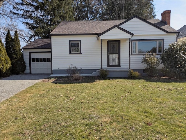 ranch-style home featuring a front lawn, an attached garage, driveway, and a shingled roof