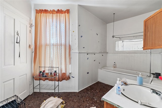 bathroom featuring a bathtub, a wainscoted wall, and vanity