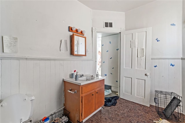 bathroom with visible vents, wainscoting, vanity, and toilet