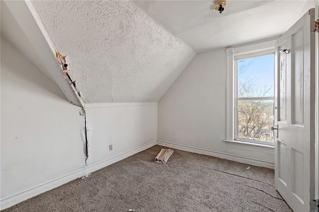 bonus room with baseboards, lofted ceiling, carpet, and a textured ceiling