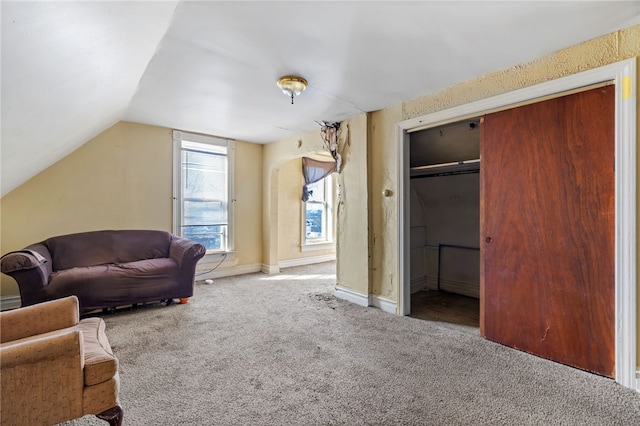 sitting room with carpet flooring, baseboards, and vaulted ceiling