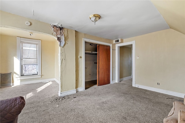 unfurnished bedroom with vaulted ceiling, carpet flooring, baseboards, and a closet