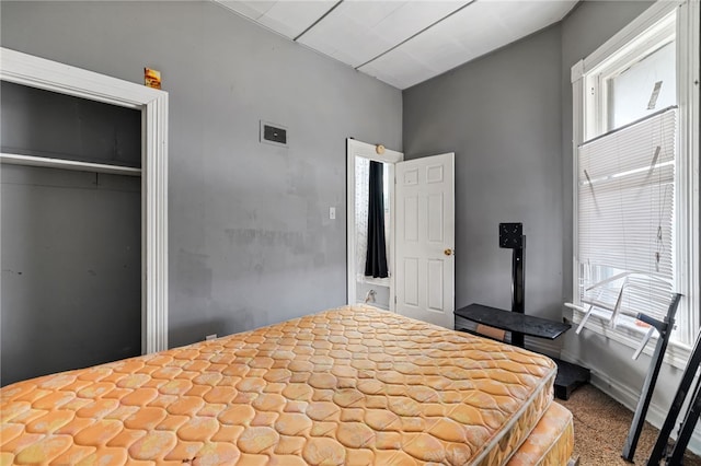 bedroom with a closet, visible vents, multiple windows, and baseboards