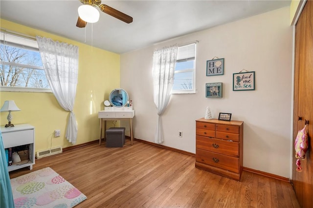 interior space featuring ceiling fan, wood finished floors, visible vents, and baseboards