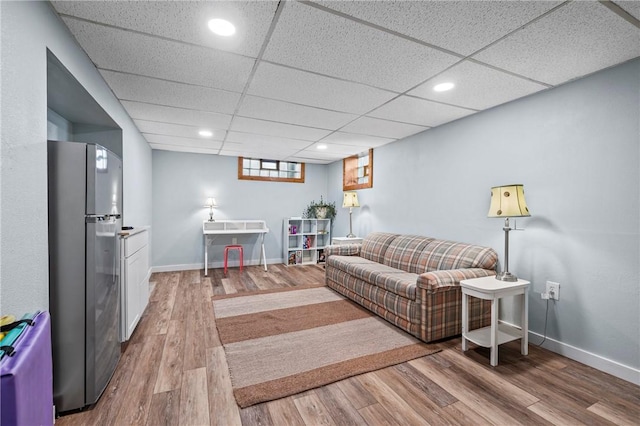 living room featuring recessed lighting, a paneled ceiling, baseboards, and wood finished floors