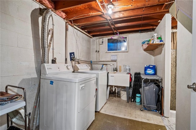 laundry room featuring laundry area, washer and dryer, light floors, and a sink