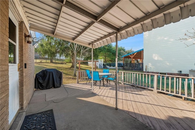 view of patio / terrace featuring outdoor dining space, a wooden deck, fence, and a grill