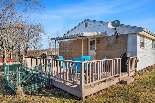 rear view of property with brick siding and a deck