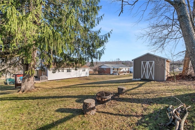 view of yard with a fire pit, an outdoor structure, and a shed