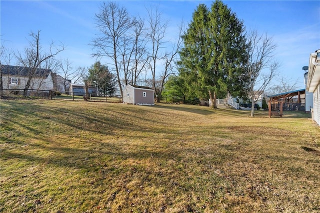 view of yard featuring a storage shed, an outdoor structure, and fence