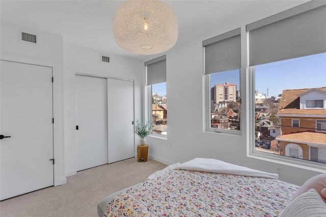 bedroom featuring carpet, visible vents, a closet, and baseboards