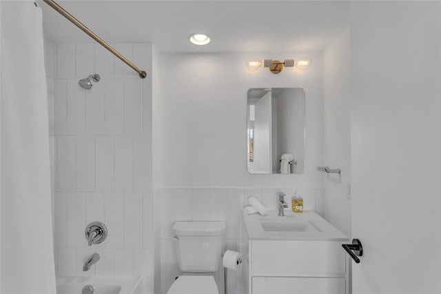 full bath with a wainscoted wall, shower / tub combo with curtain, toilet, tile walls, and vanity