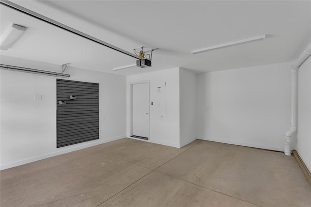 garage featuring a garage door opener and baseboards