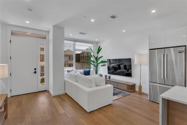 living area with recessed lighting and light wood-style floors