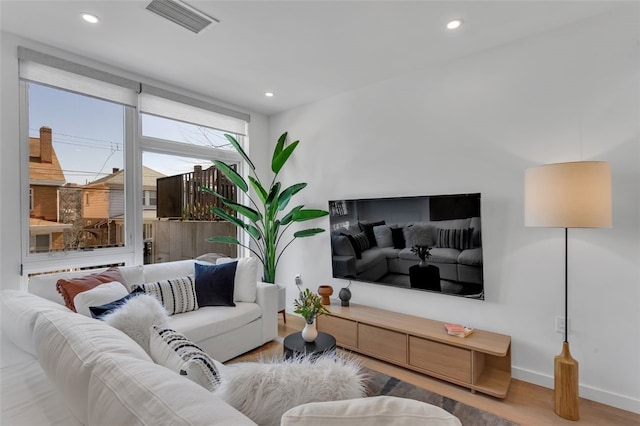 living room with recessed lighting, wood finished floors, visible vents, and baseboards