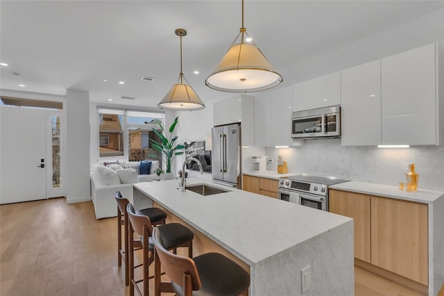 kitchen with decorative backsplash, appliances with stainless steel finishes, modern cabinets, and a sink