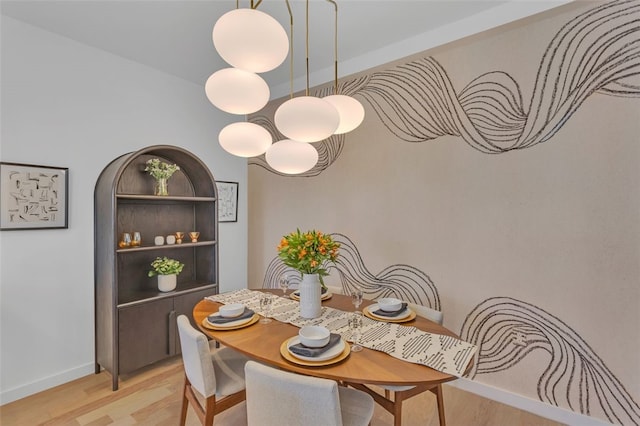 dining room featuring light wood-style flooring and baseboards