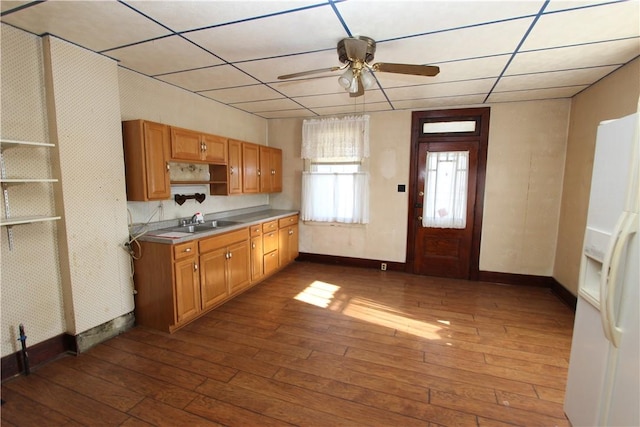 kitchen featuring dark wood finished floors, white refrigerator with ice dispenser, a ceiling fan, and open shelves