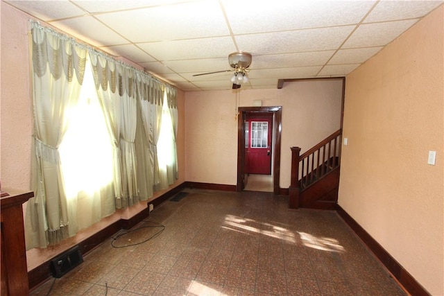 entrance foyer with tile patterned floors, a drop ceiling, baseboards, and visible vents