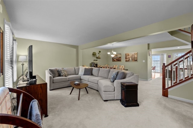 living room with stairway, a notable chandelier, light colored carpet, and baseboards