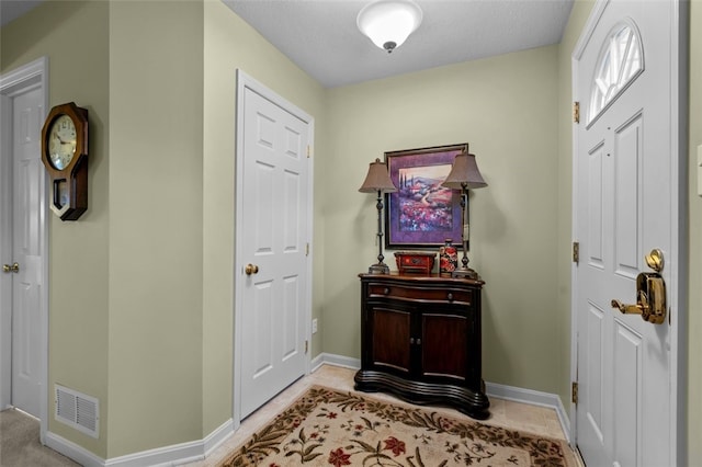 entryway featuring light tile patterned flooring, baseboards, and visible vents