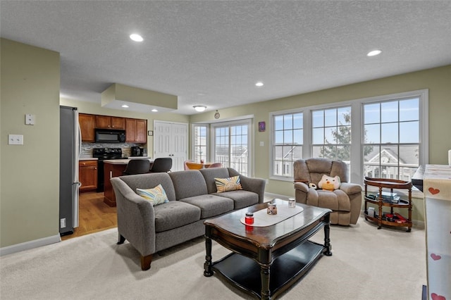 living area featuring recessed lighting, baseboards, and light colored carpet