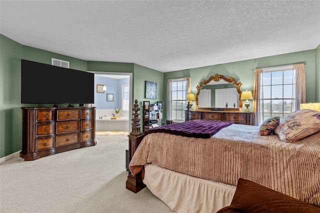 carpeted bedroom with baseboards, visible vents, ensuite bathroom, and a textured ceiling