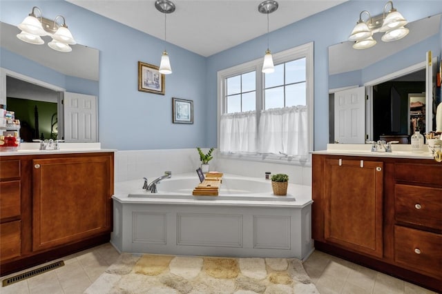 full bathroom with visible vents, two vanities, a sink, a garden tub, and a notable chandelier