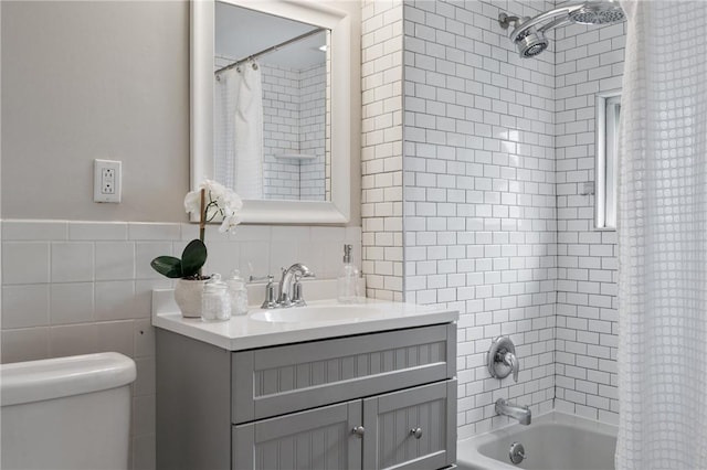 full bath featuring shower / bath combo with shower curtain, toilet, tile walls, and vanity