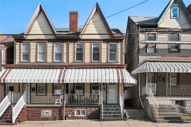 multi unit property with covered porch and a chimney