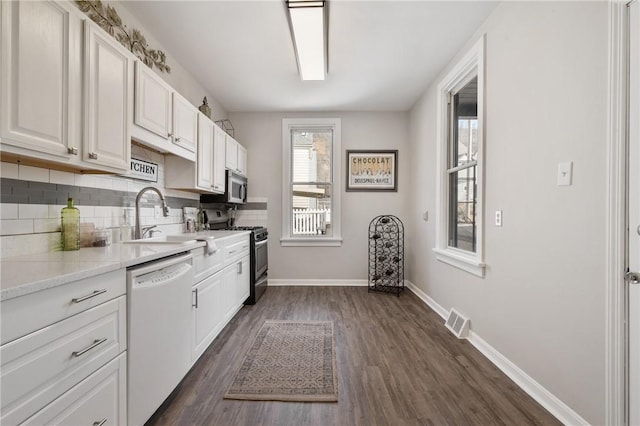 kitchen featuring visible vents, backsplash, white cabinetry, stainless steel appliances, and dark wood-style flooring