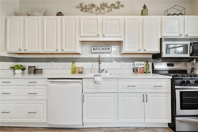 kitchen featuring gas range, decorative backsplash, white dishwasher, white cabinetry, and a sink