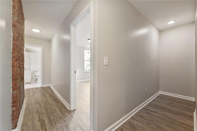 hallway featuring baseboards and wood finished floors