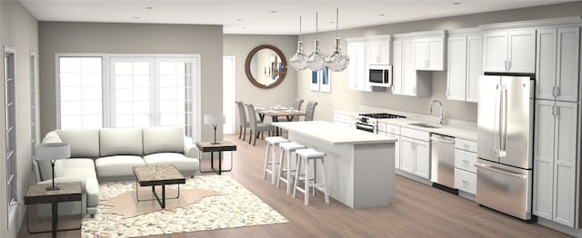 kitchen with a kitchen bar, wood finished floors, a center island, stainless steel appliances, and light countertops