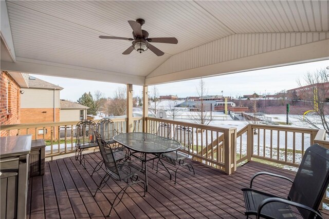 wooden terrace with outdoor dining area and a ceiling fan