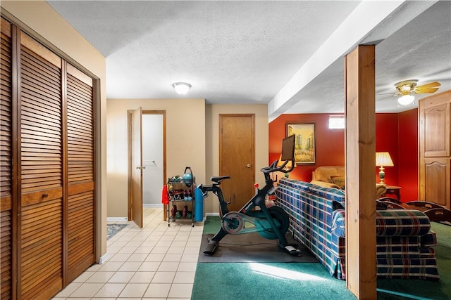 interior space featuring light tile patterned floors, baseboards, a textured ceiling, and ceiling fan