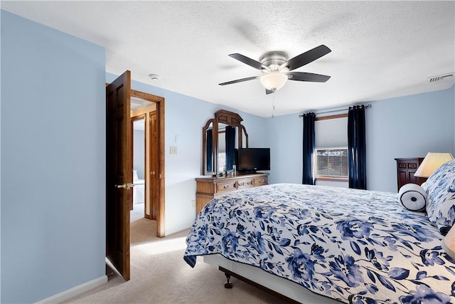 bedroom with visible vents, baseboards, ceiling fan, light carpet, and a textured ceiling