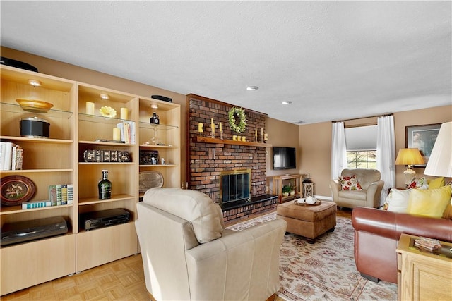 living area with a brick fireplace and a textured ceiling