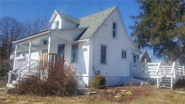 exterior space with stairs, a ceiling fan, and covered porch