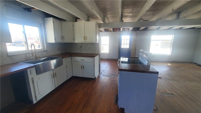 kitchen featuring beamed ceiling, electric range oven, dark wood-style floors, wall chimney exhaust hood, and a sink