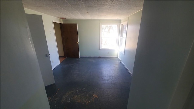 empty room featuring baseboards and concrete flooring