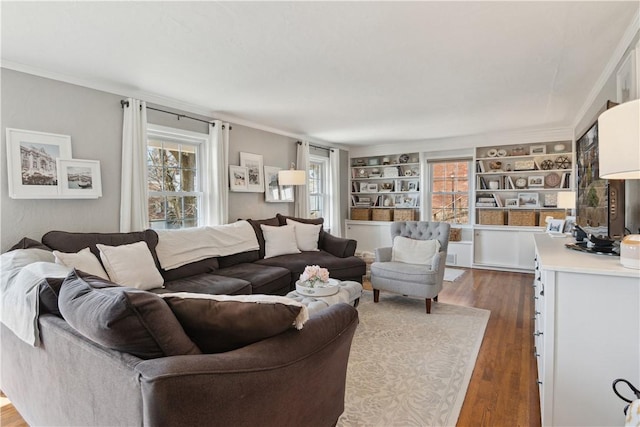 living area featuring ornamental molding, built in shelves, and wood finished floors