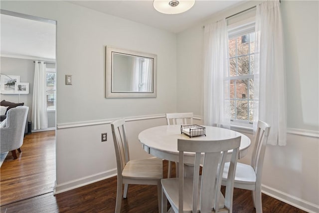 dining space with dark wood finished floors and baseboards