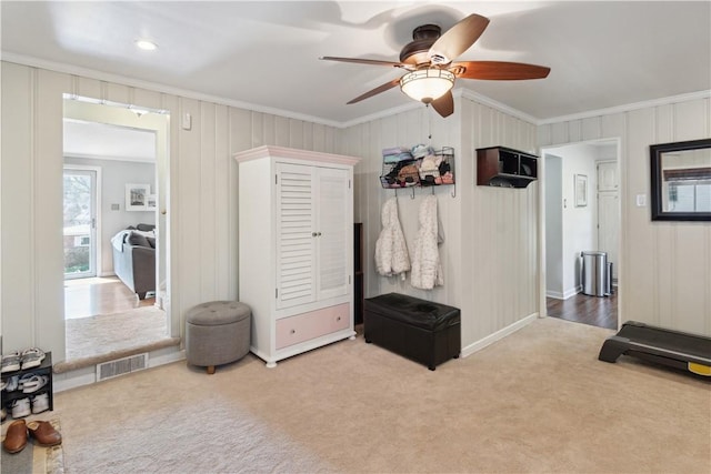 carpeted bedroom with visible vents, ceiling fan, and ornamental molding